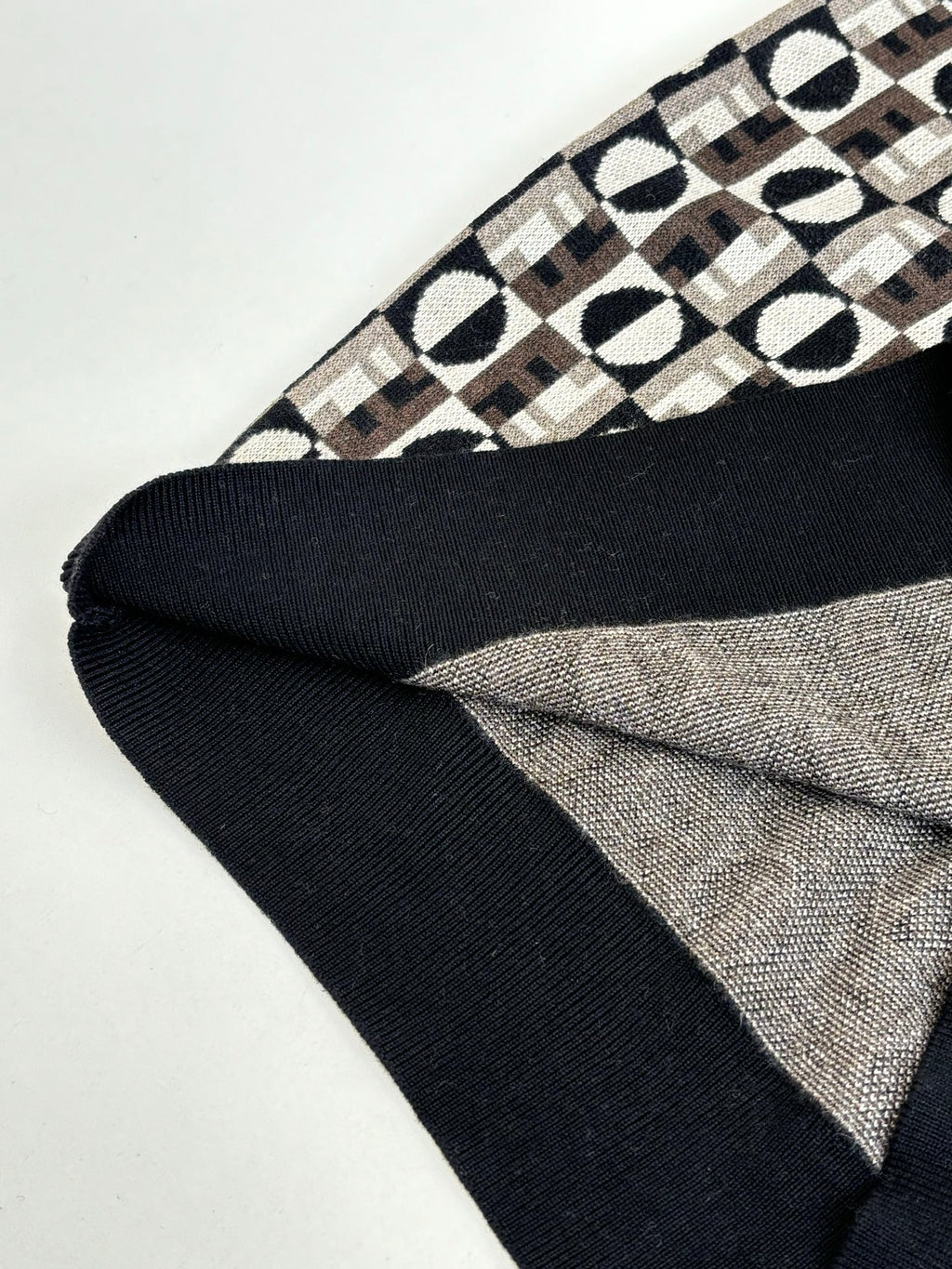 Knit sweater hem with black ribbed edging and Fendi monogram patterned body
