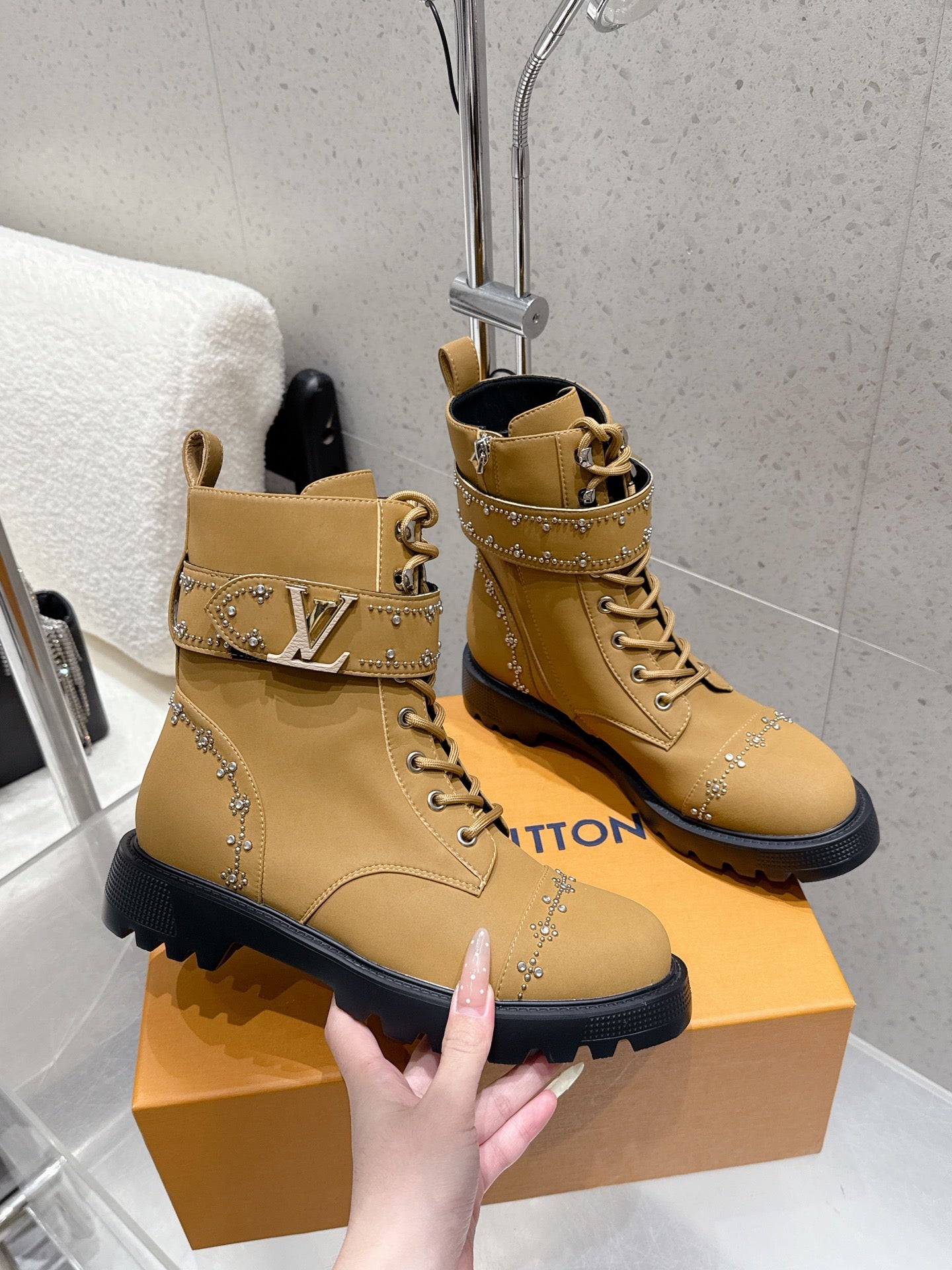 Tan lace-up ankle boots with LV logo strap, studded accents, black sole