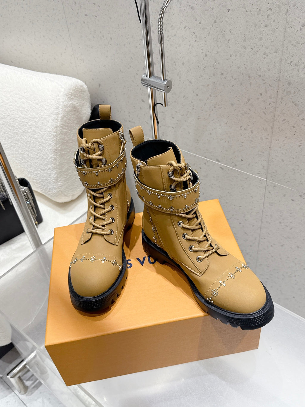 Pair of tan lace-up ankle boots with studded side trim and black sole