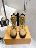 Tan lace-up ankle boot with studded trim and chunky rubber sole, on box