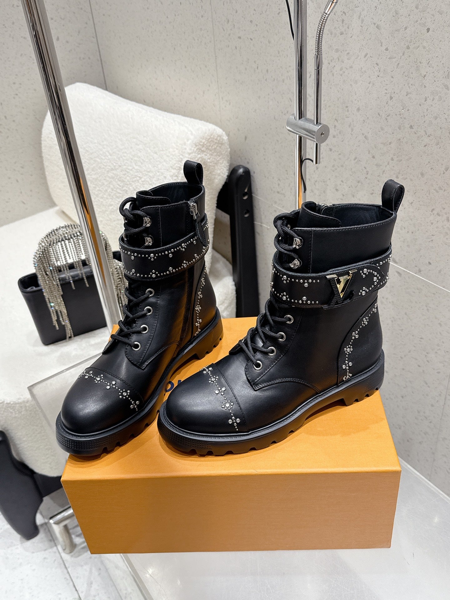 Black studded lace-up boots with metal eyelets and textured sole