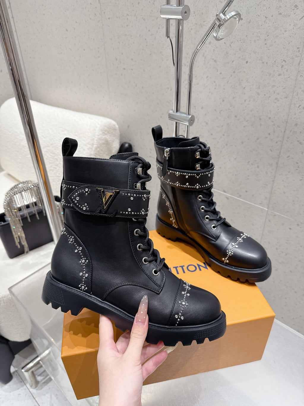 Black studded lace-up boots on tan box; front pair view