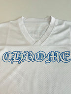 White V-neck jersey chest close-up with large blue embroidered-style word graphic