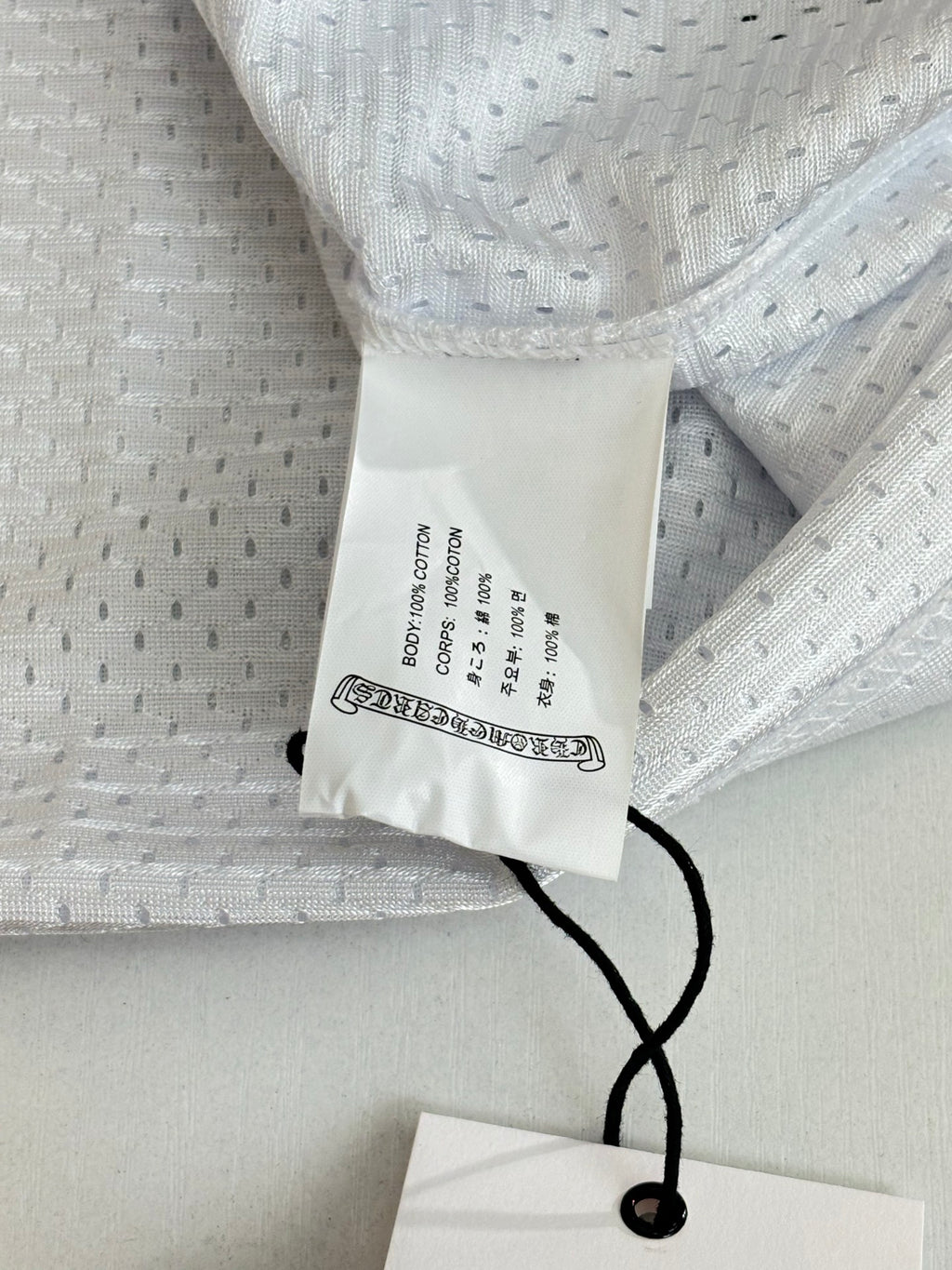White long-sleeve jersey neck label and black string tie detail