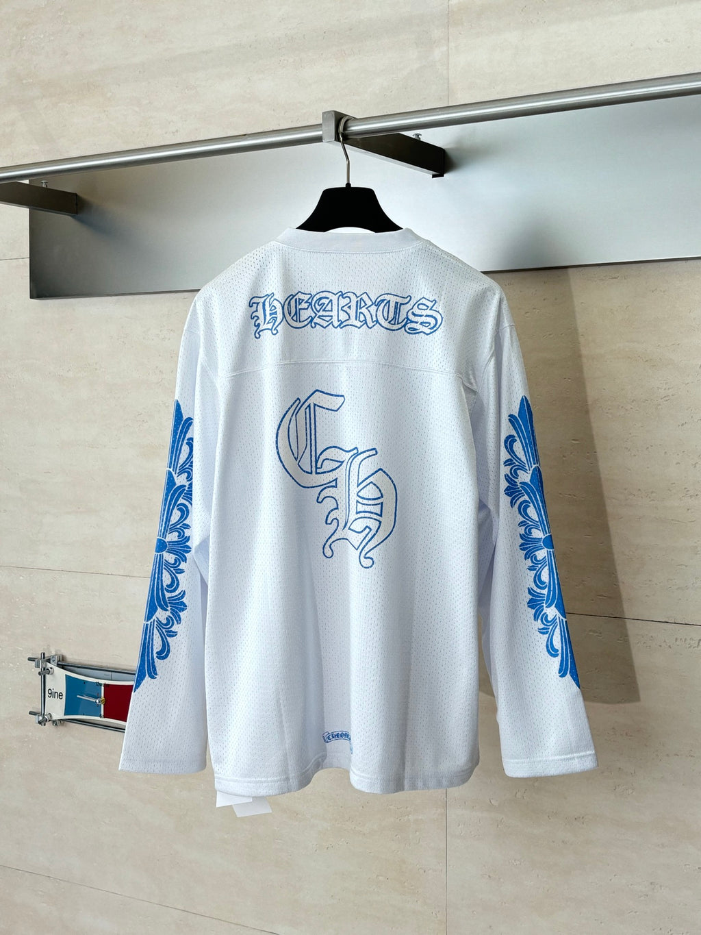 White long-sleeve V-neck jersey, back view with blue text and crest graphic