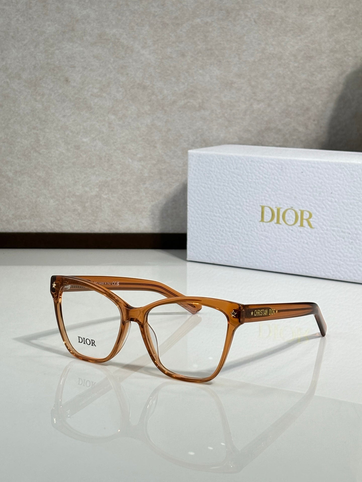 Amber brown eyeglass frames with clear lenses and logo on temple