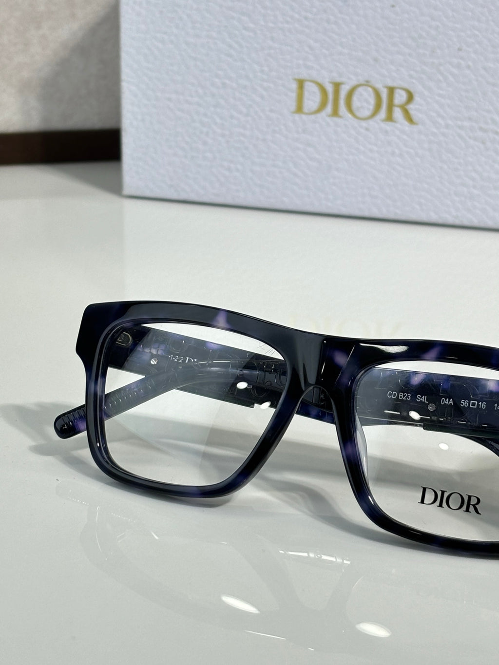 Dior rectangular eyeglasses with dark blue-tinted frames, close-up side view