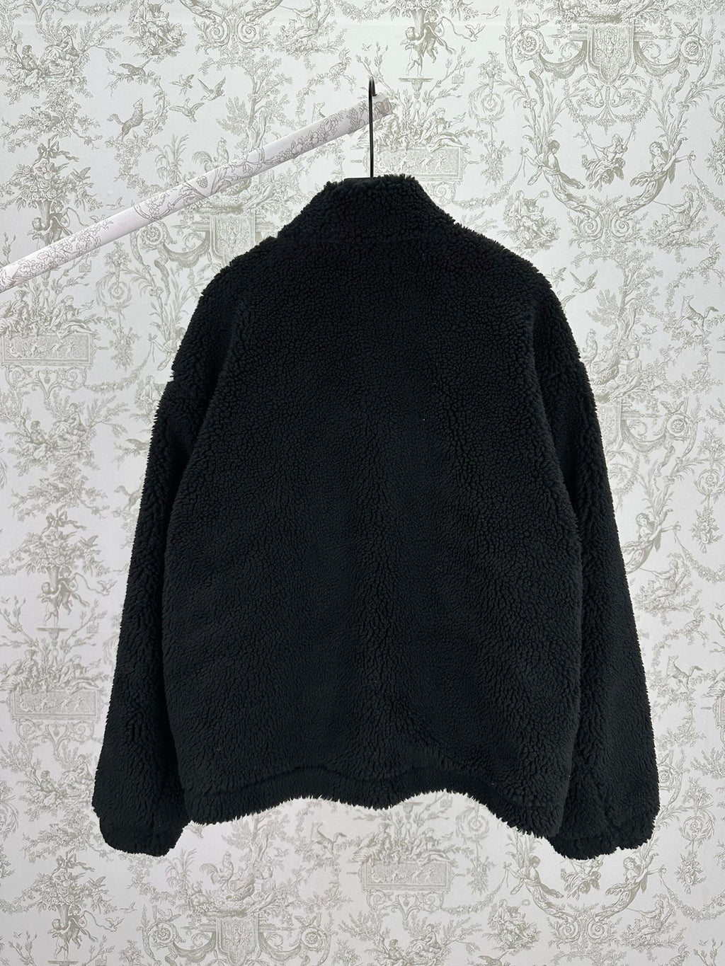 Black shearling-style jacket back view with full-length zip and raised collar