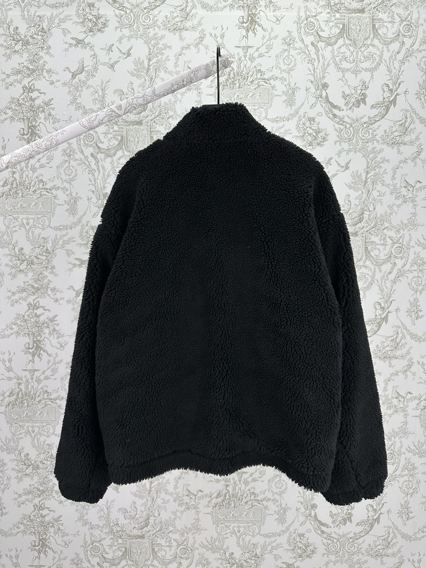 Black shearling-style jacket back view with full-length zip and raised collar