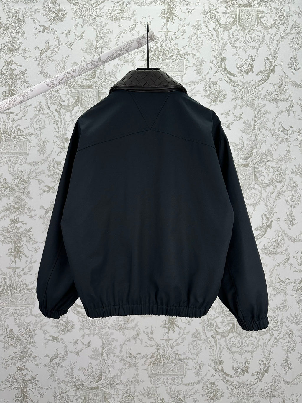 Dark jacket back view with ribbed hem and stand collar