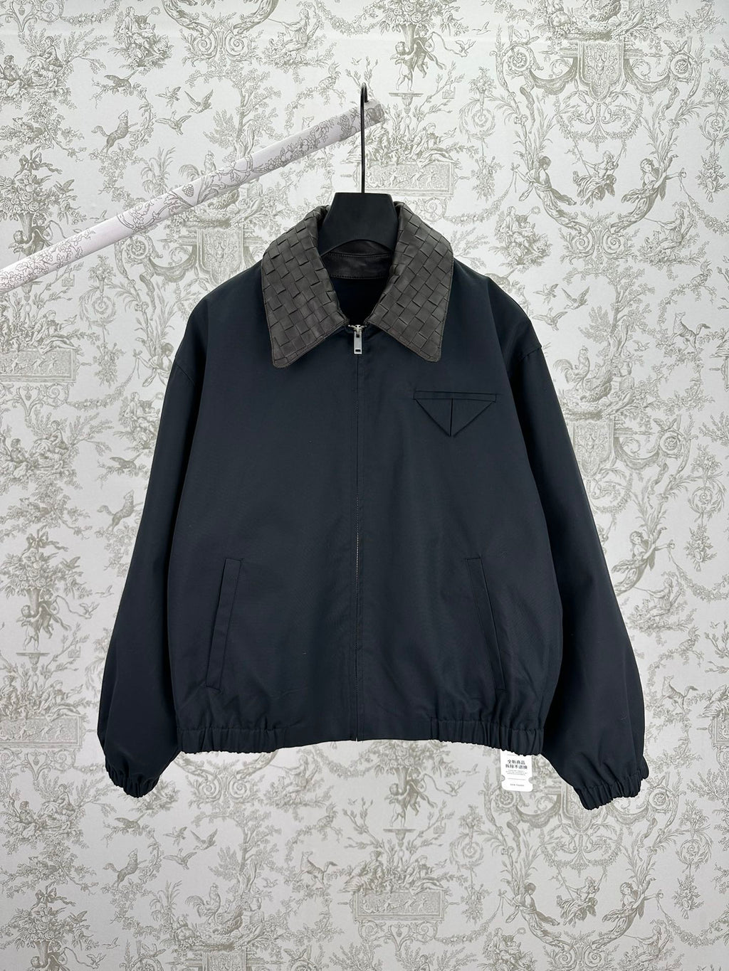 Dark zip-up jacket with stand collar and chest logo pocket