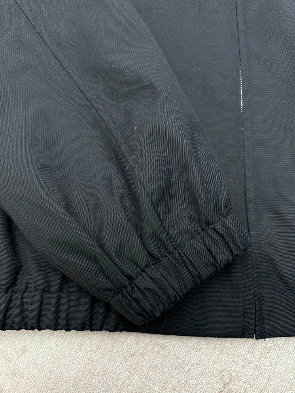 Dark jacket sleeve and hem with elastic cuff and gathered finish