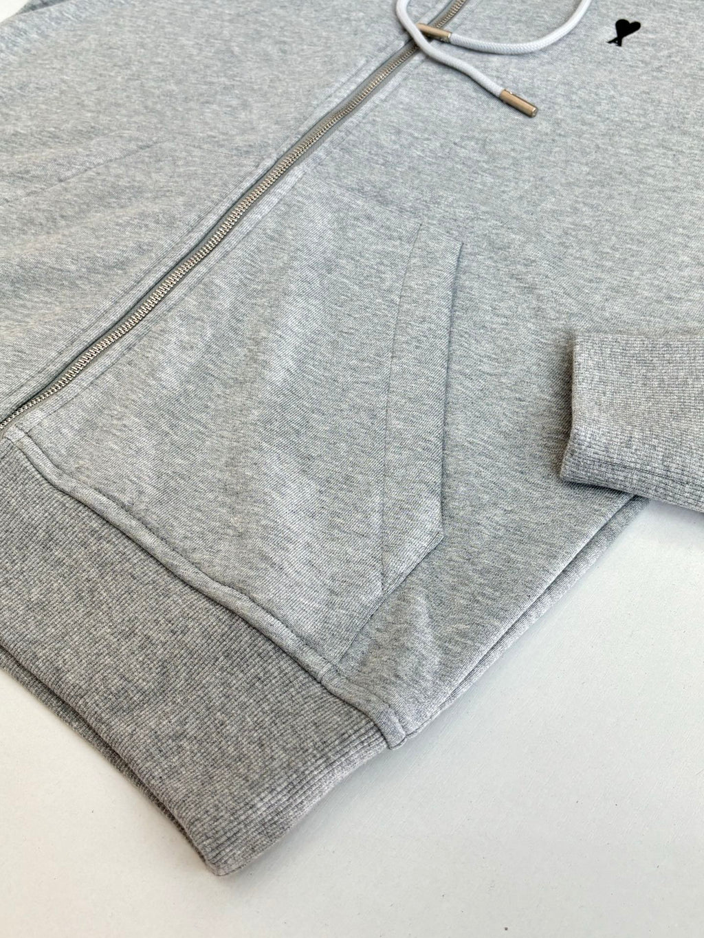 Amiri hoodie close-up showing metal zipper and gray drawcord inside hood