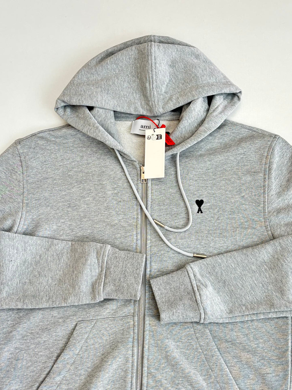 Amiri light gray hoodie close-up: hood, drawstrings, full-zip front