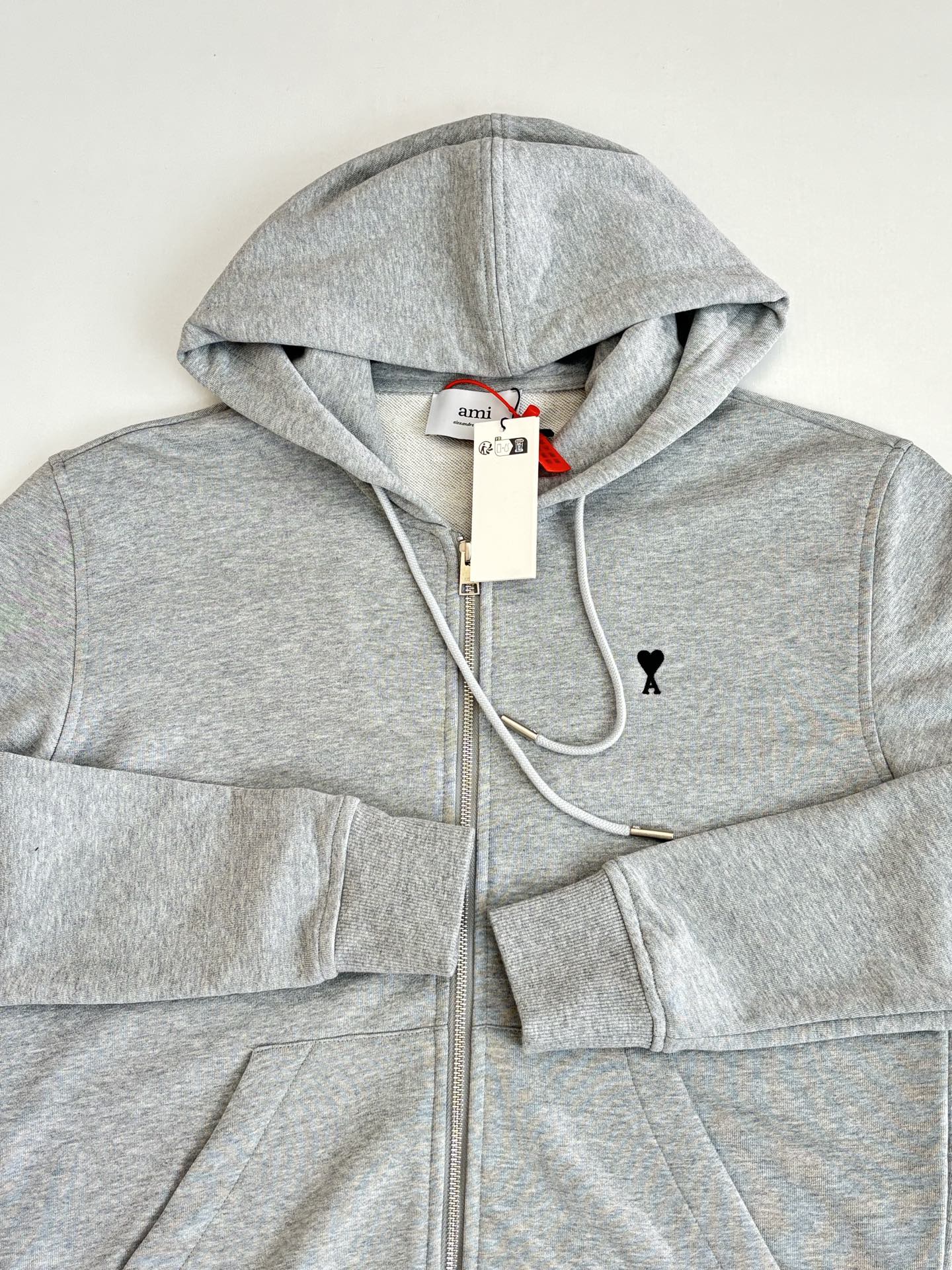 Amiri light gray hoodie close-up: hood, drawstrings, full-zip front