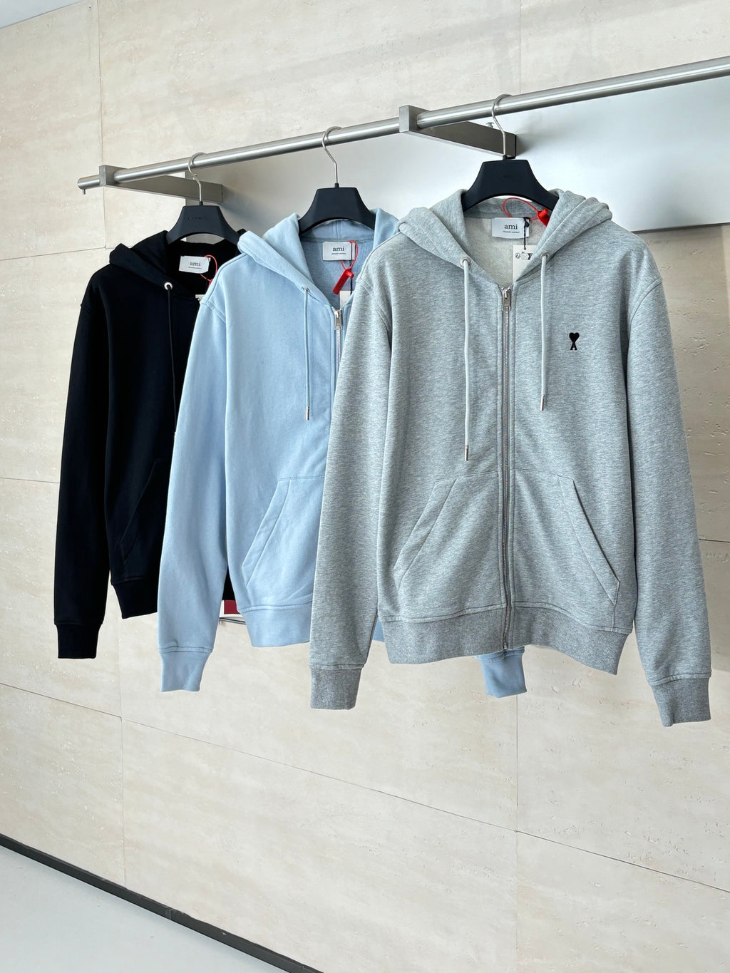 Amiri hoodie set on hangers: light blue and light gray zip-up hoodies
