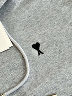 Amiri hoodie fabric close-up with small black silhouette emblem on chest