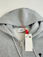 Amiri light gray hoodie neckline close-up with brand patch and hood drawstrings