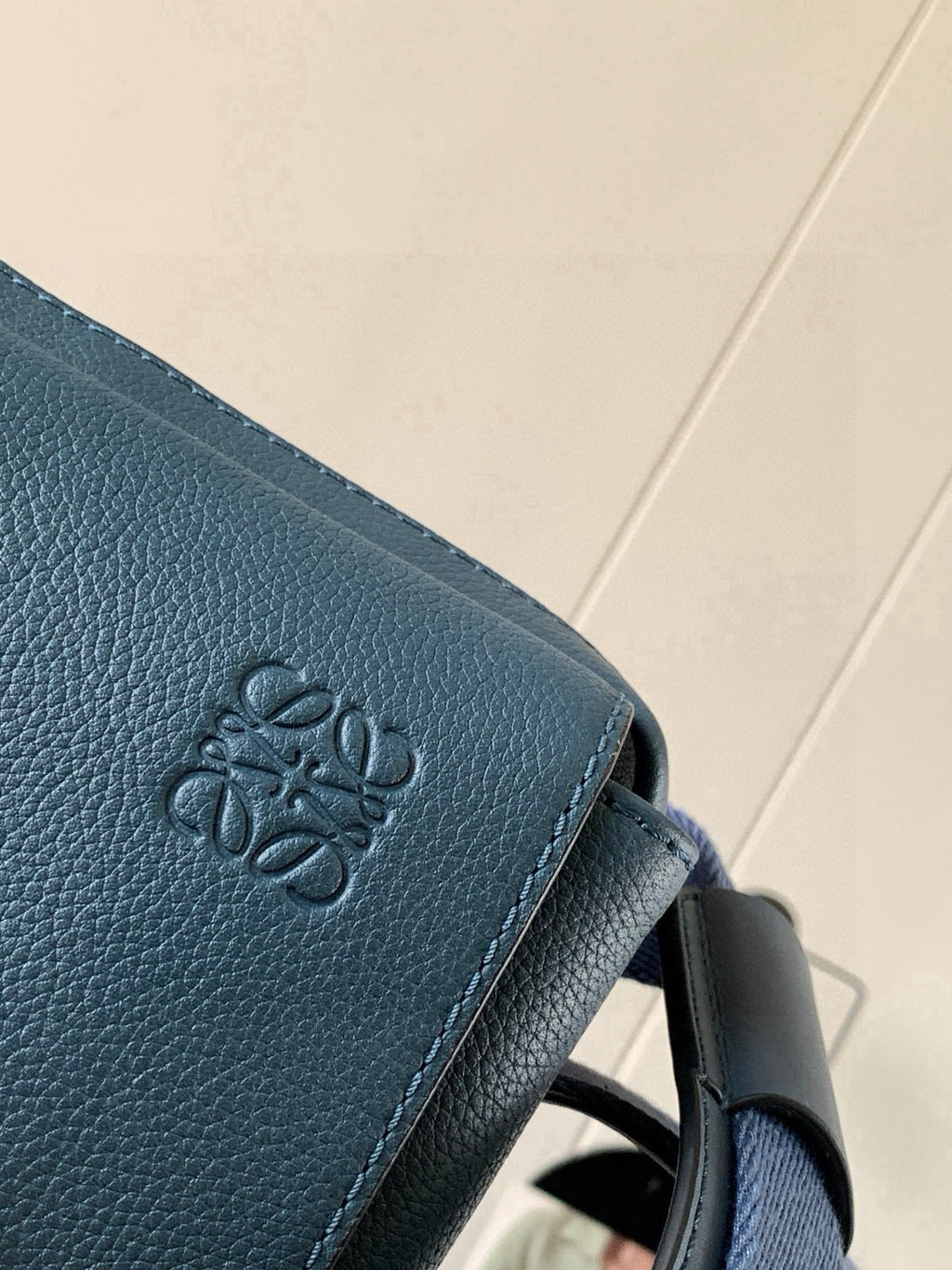 Loewe blue leather bag close-up of embossed logo on flap