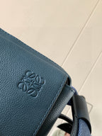 Loewe blue leather bag close-up of embossed logo on flap