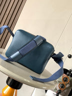 Blue Loewe crossbody bag with front flap, adjustable shoulder strap, side view