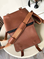 Leather crossbody bag with flap, dual strap, and embossed logo on front