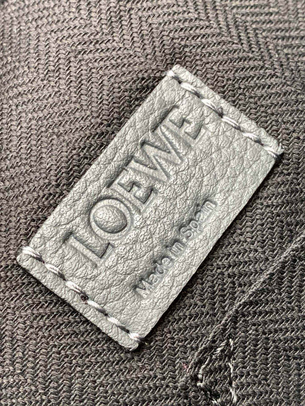 LOEWE embossed leather patch label on fabric lining with stitching