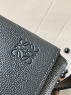 Gray leather flap with embossed logo detail and stitched edge