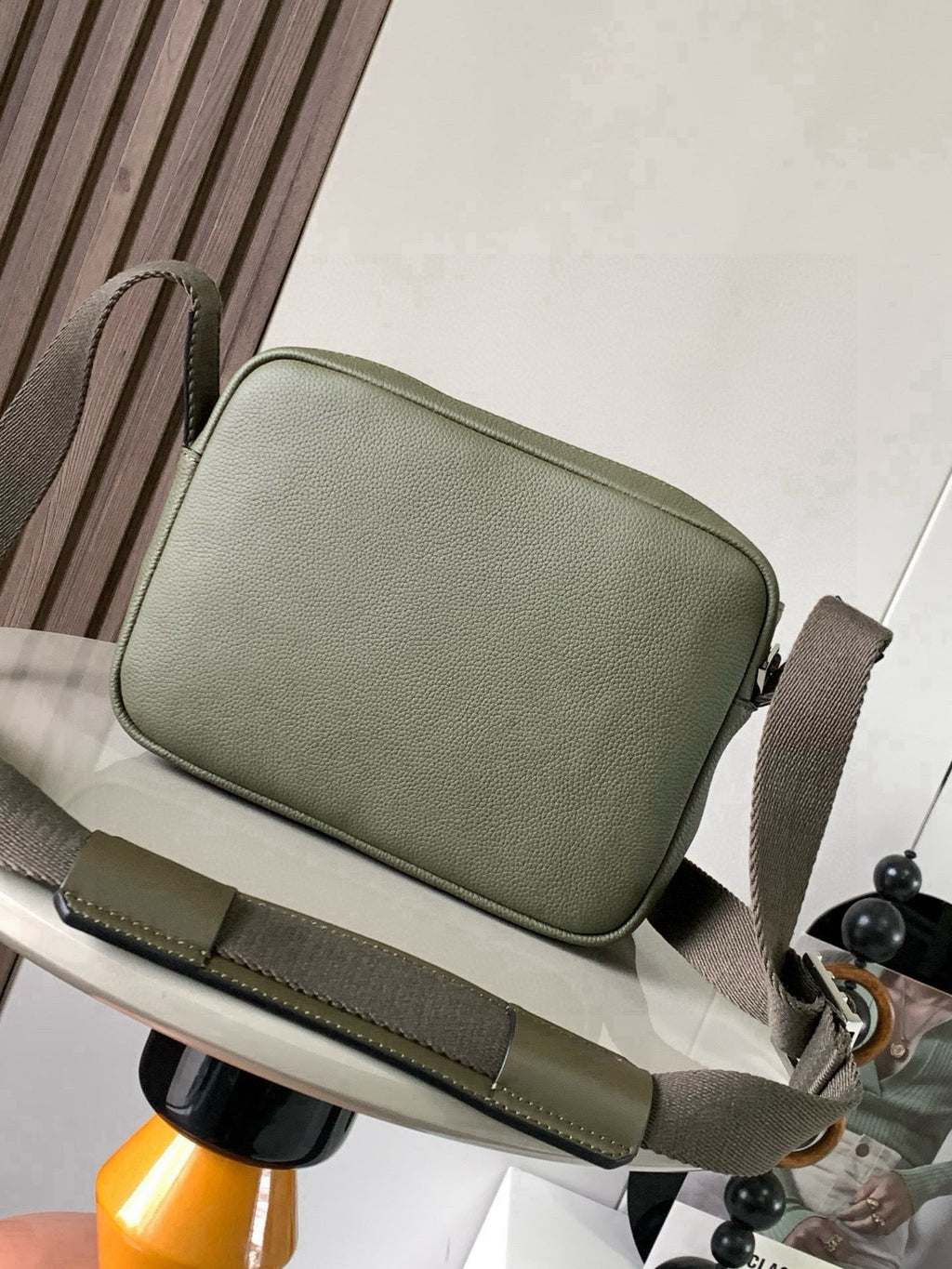 Sage green crossbody bag with zip top, structured shape, and adjustable strap