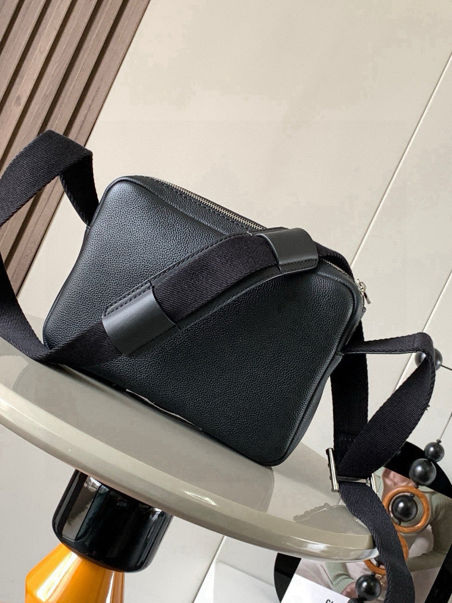 Loewe crossbody bag in dark leather with front strap band and buckle fastening.