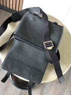 Dark leather small backpack-style bag with metal buckles and shoulder straps