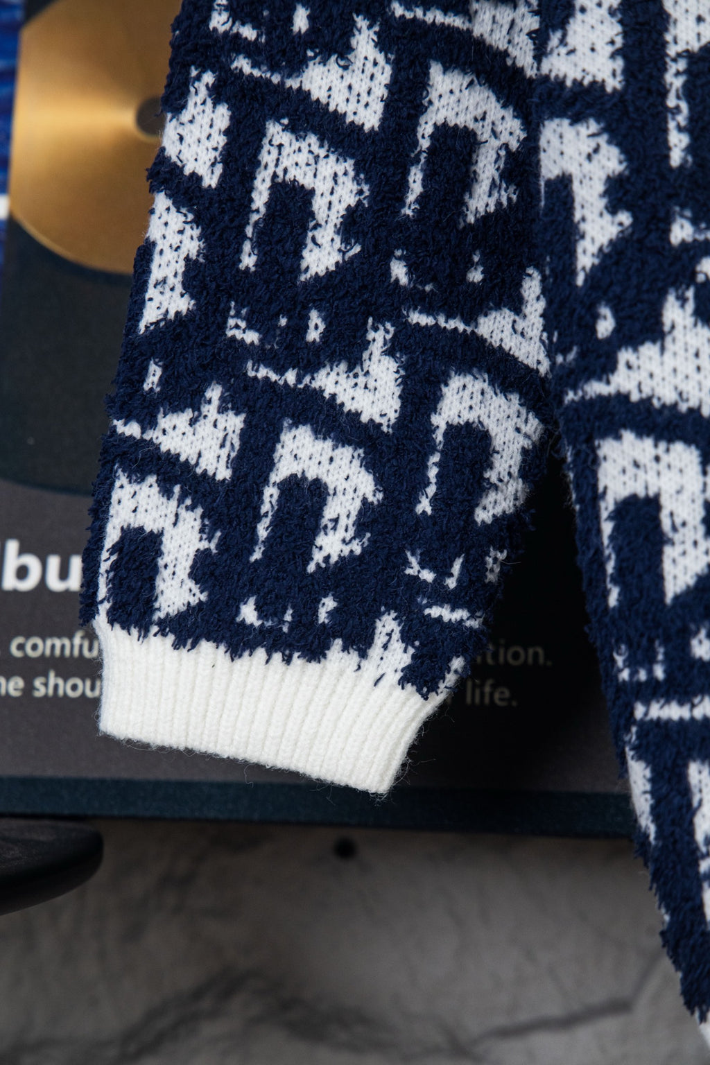 Knit cardigan sleeve with ribbed white cuff and navy-and-white geometric pattern