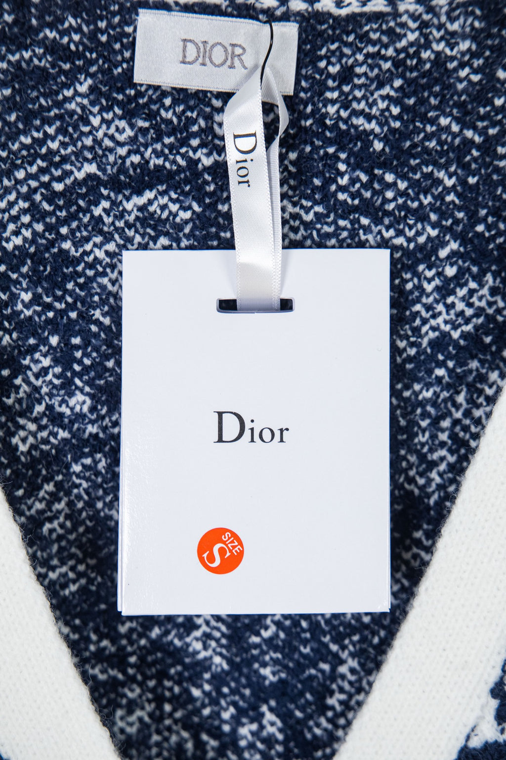 Knit cardigan with hanging Dior tag and navy-and-white speckled pattern