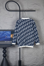Long-sleeve knit cardigan with navy-and-white geometric pattern, ribbed cuffs