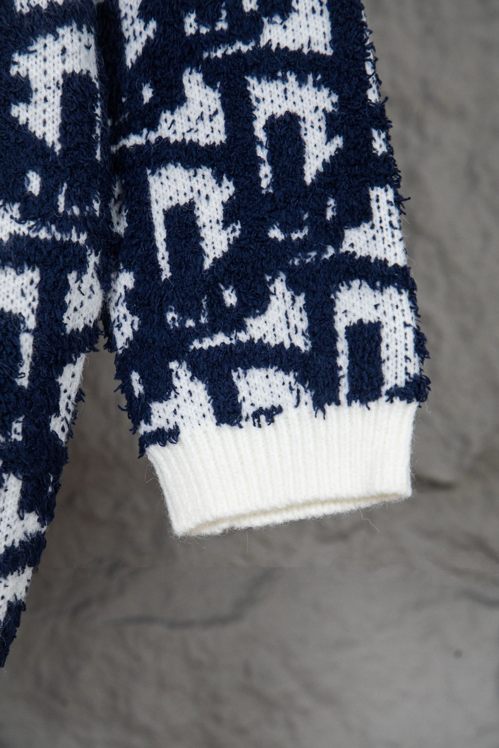 Knit cardigan hem with ribbed white band and navy-and-white geometric pattern