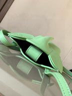 Loewe mint green leather mini bag open with visible black interior lining and strap