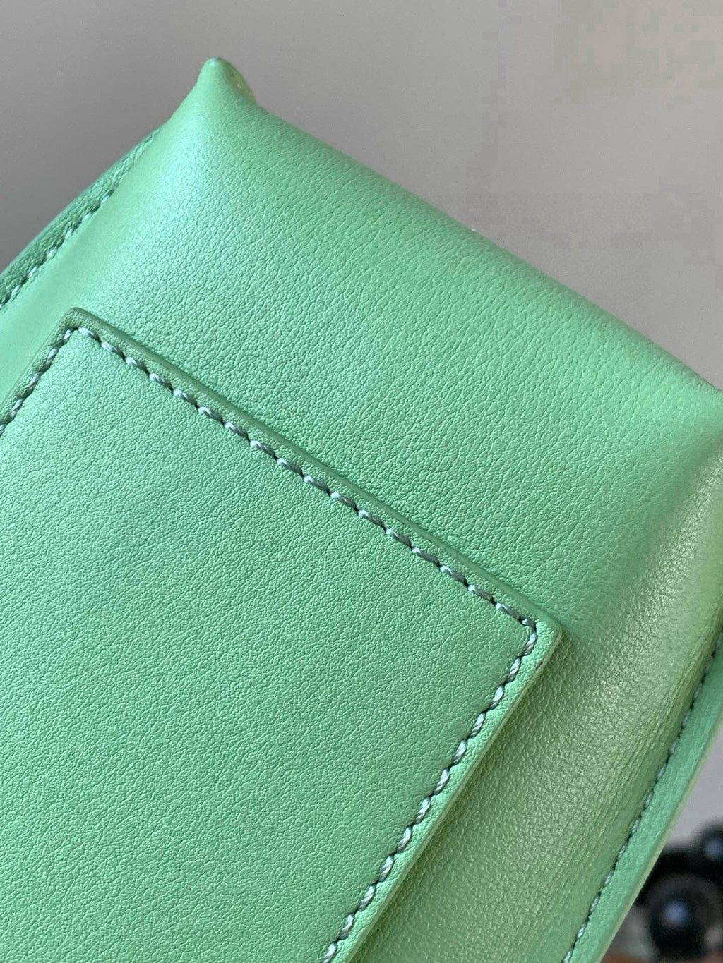 Loewe mint green leather flap with stitched panel and textured grain close-up