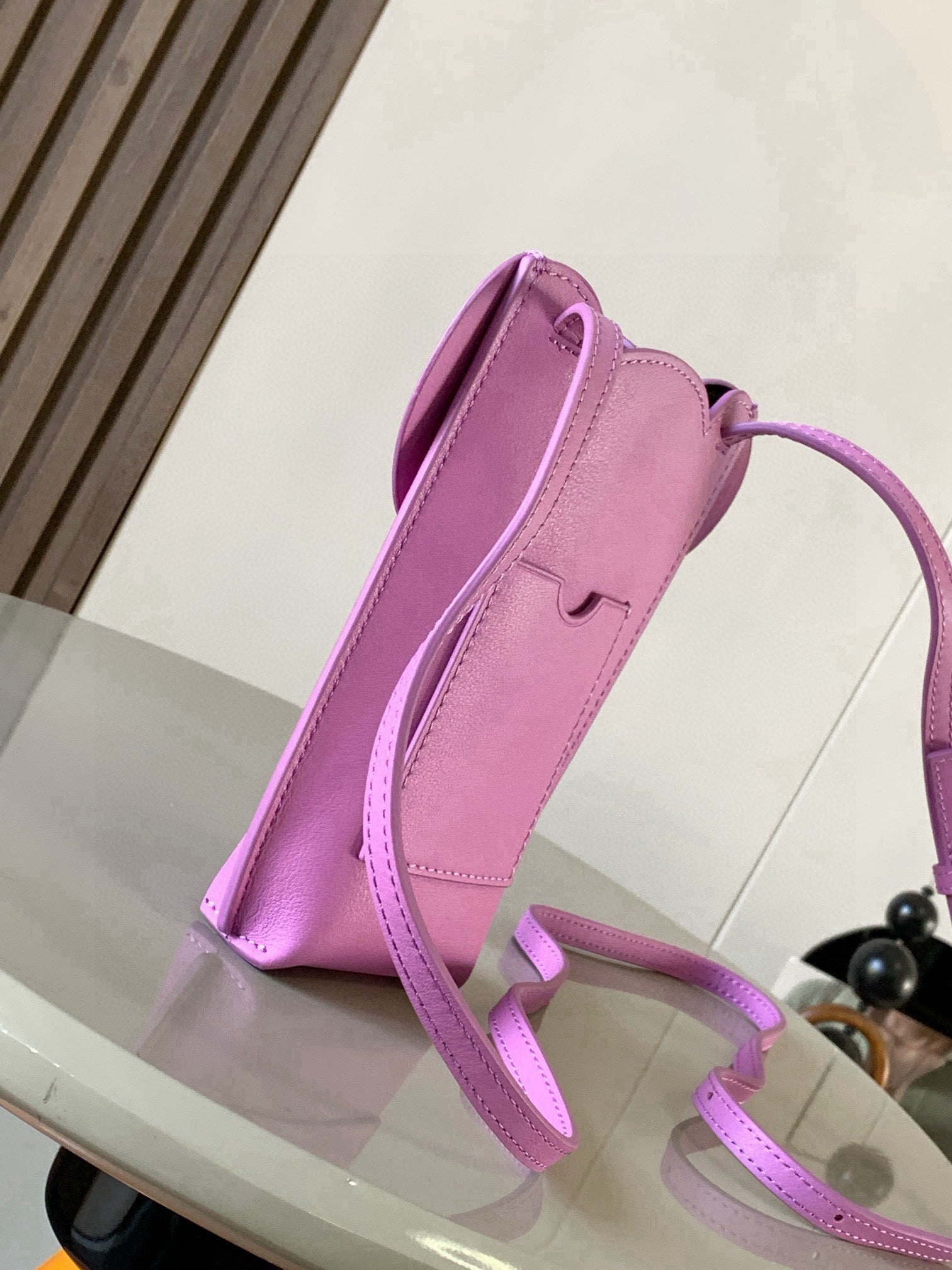 Loewe bag in lilac leather, angled view with long shoulder strap and flap closure