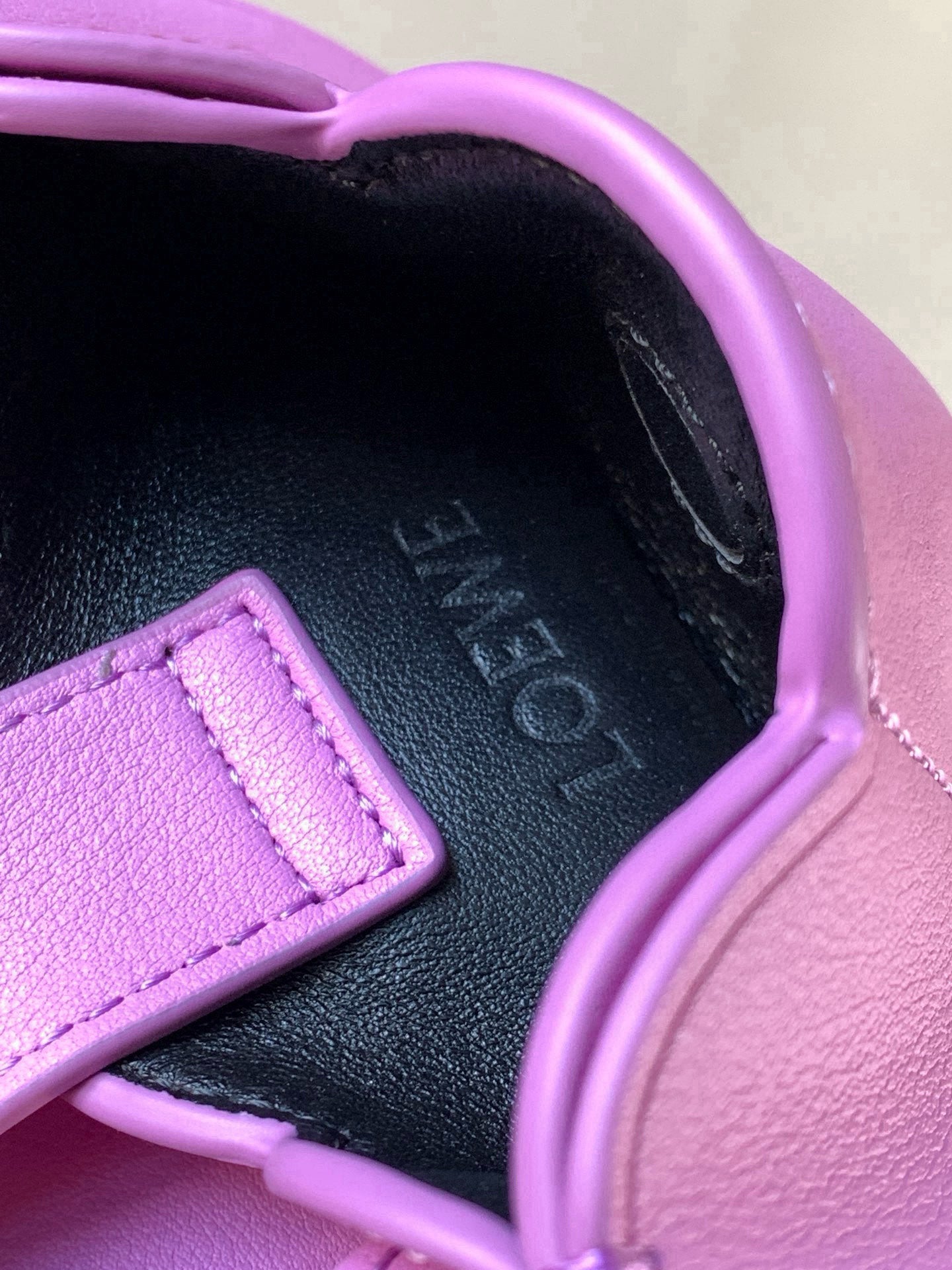 Loewe bag interior view with embossed logo and lilac leather strap trim