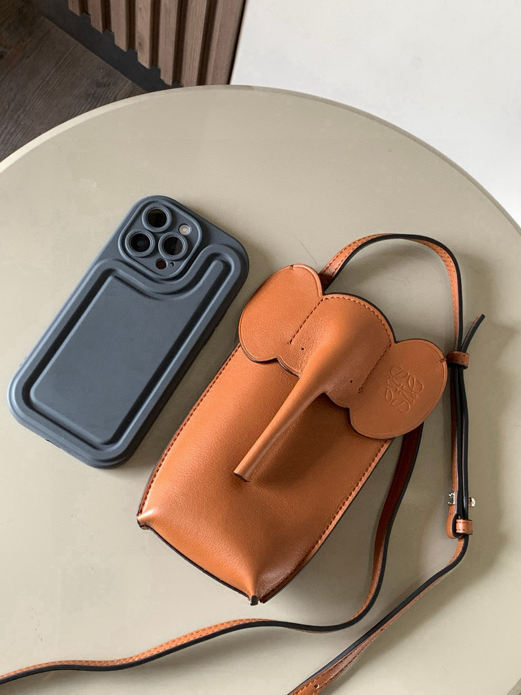 Loewe small leather crossbody bag with phone accessory beside, tan-brown