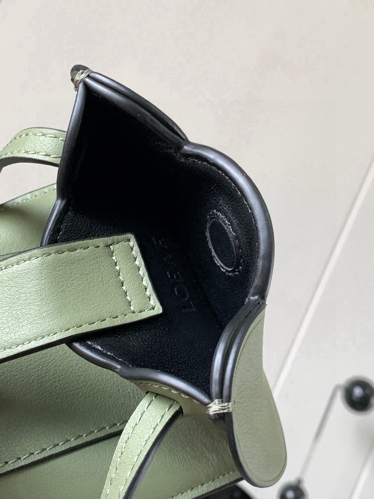 Mint green and dark interior mini bag with rounded opening and stitched edge detailing
