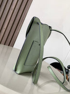 Mint green leather mini crossbody bag with structured sides and adjustable shoulder strap