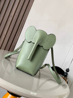 Mint green leather mini bag with top handle and crossbody strap, front flap detail