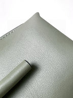 Mint green leather mini bag close-up of textured grain and top handle tab