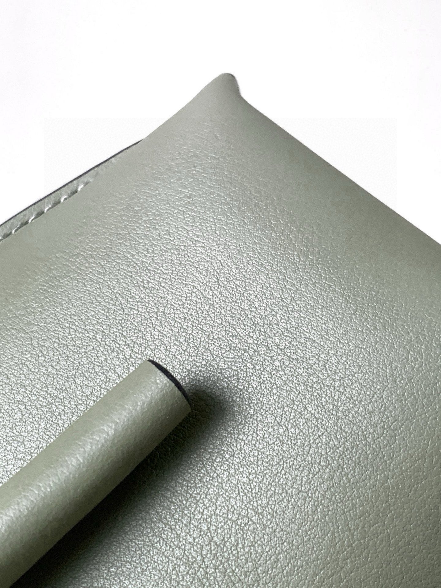 Mint green leather mini bag close-up of textured grain and top handle tab