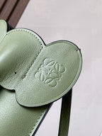 Mint green leather bag flap with embossed logo and stitched edge trim