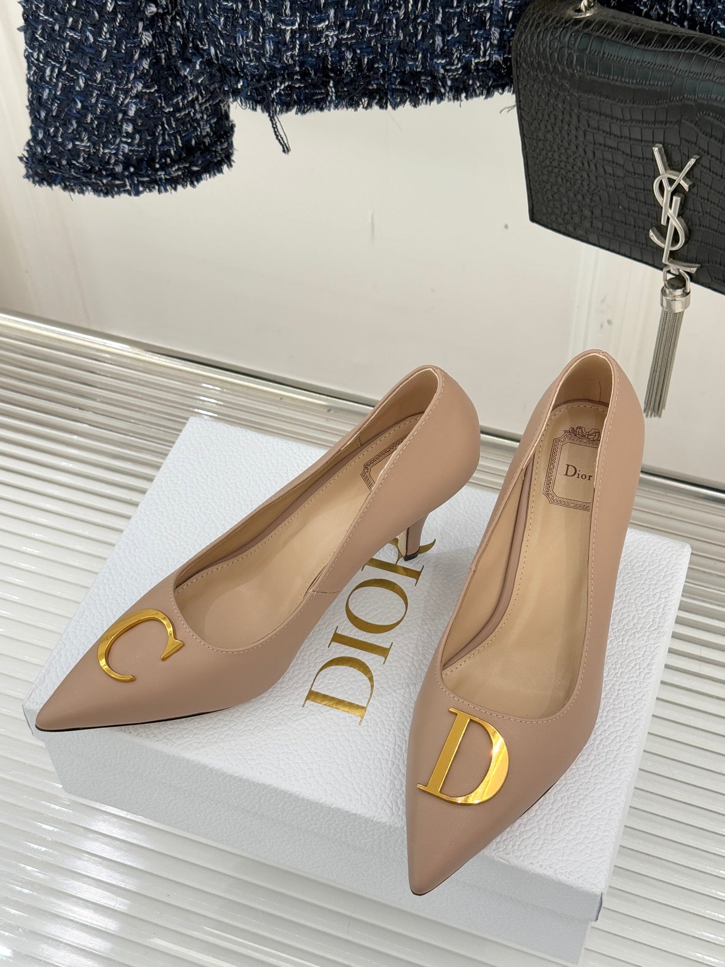 Beige Dior pointed-toe stiletto pumps with gold C and D logo hardware, side view