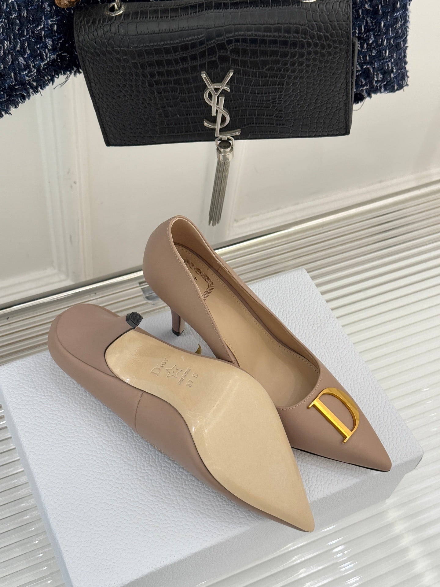 Beige Dior pointed-toe stiletto pumps side-by-side with gold D logo detail