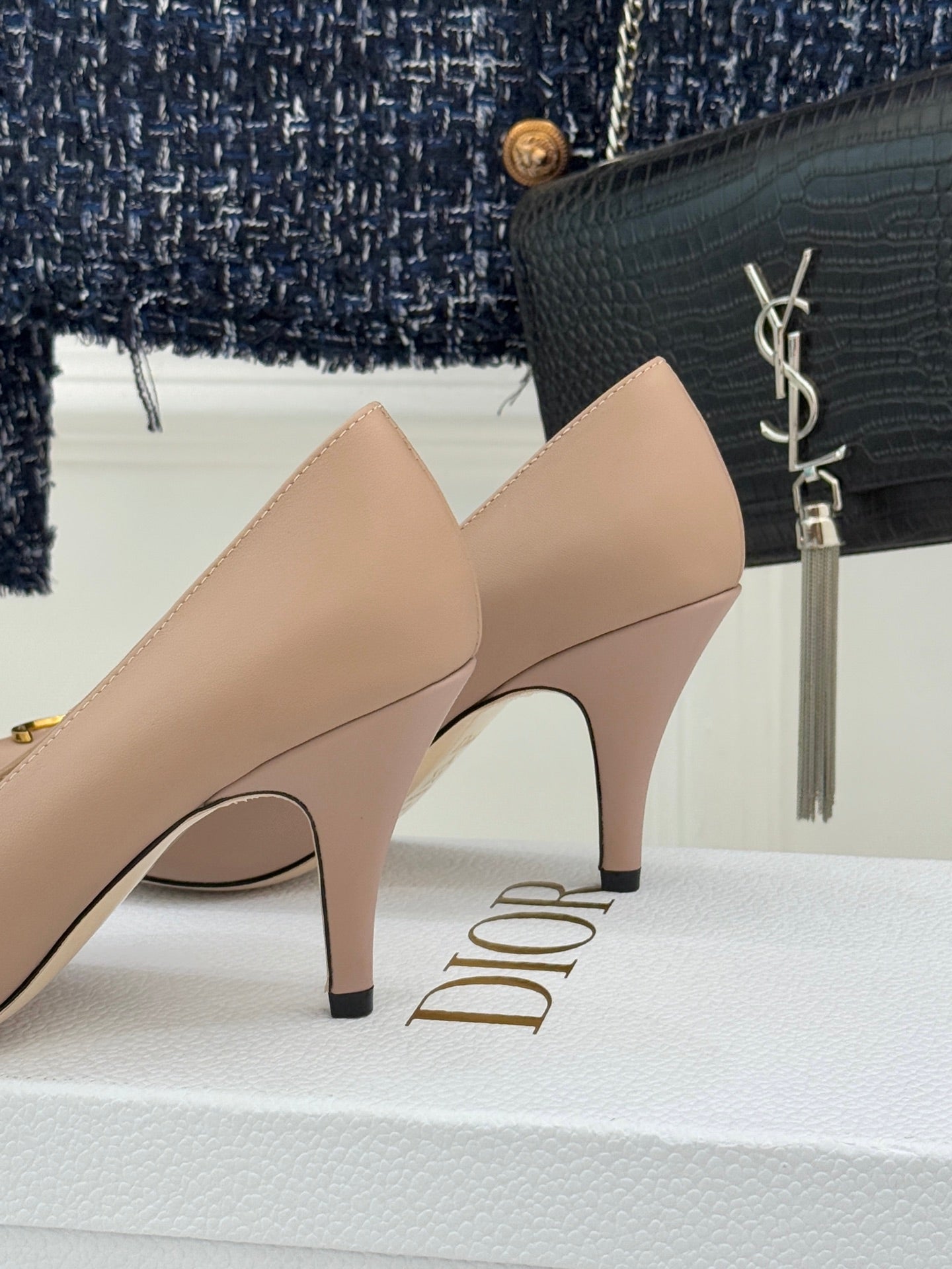 Beige Dior pointed-toe stiletto pumps with gold logo hardware, side close-up