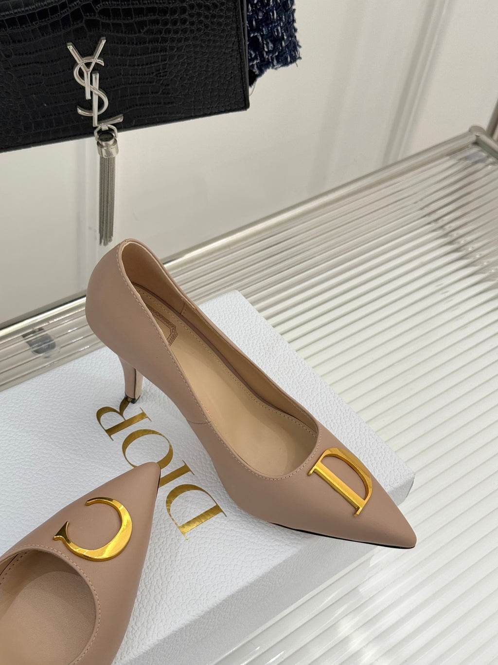 Beige Dior pointed-toe stiletto pumps with gold logo detail, three-quarter view